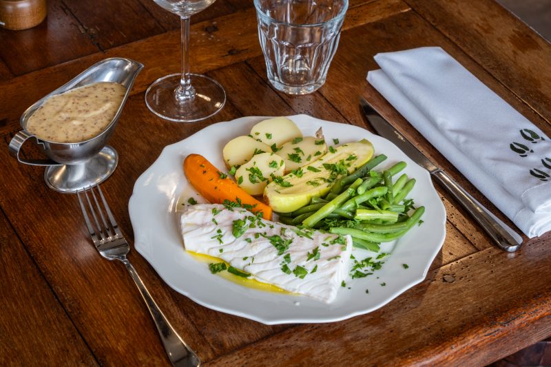 Un poisson blanc et ses légumes de saison, la sauce servie à part.